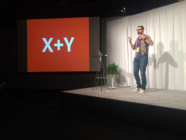 Neven Mrgan on stage, next to a projector screen showing simply "X+Y."
